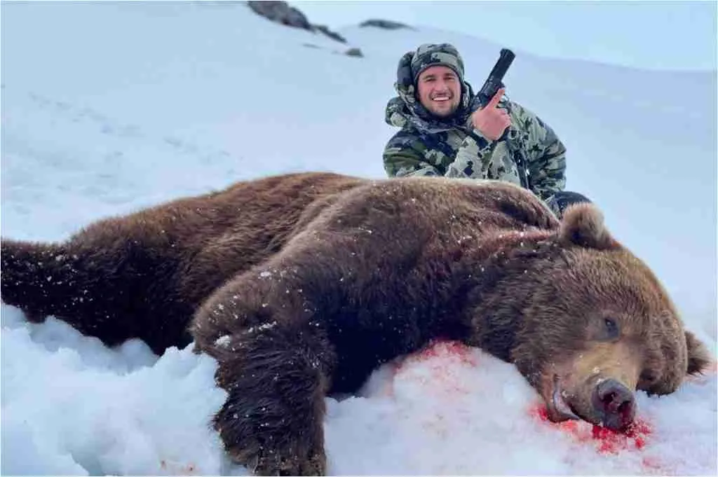 A picture of a man and the grizzly bear he killed